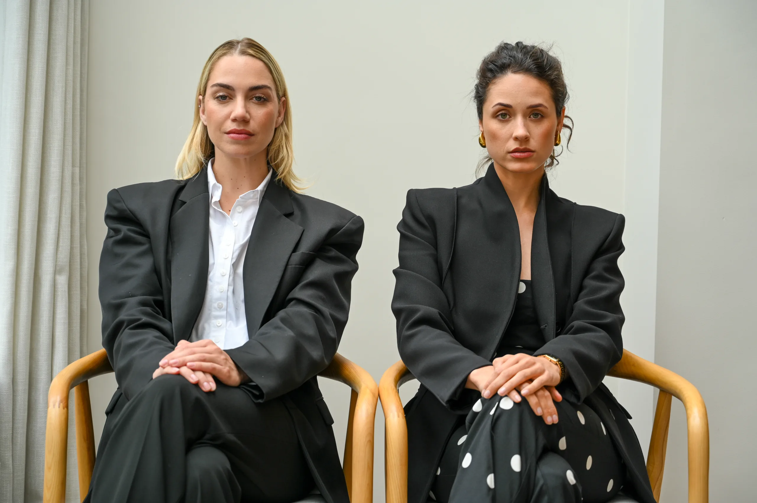 Twee vrouwen die naast elkaar op stoelen zitten.