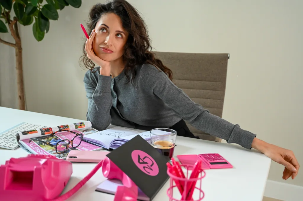 Een vrouw achter haar bureau die aan het nadenken is.